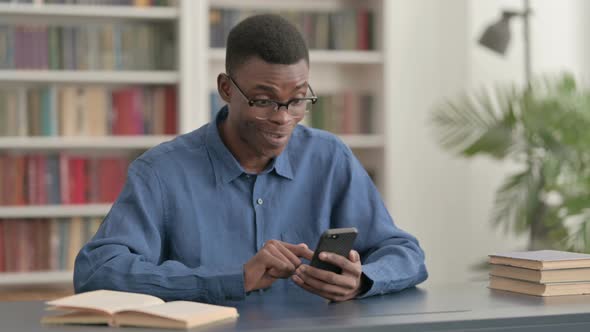 Successful Young African Man Celebrating on Smartphone