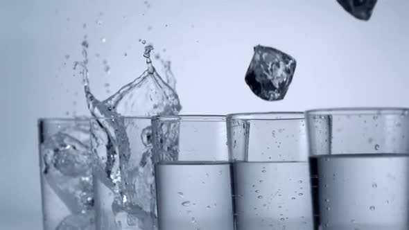 Slo-motion ice cubes falling into glass