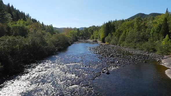 Wide View Moving Smoothly Over Water Flowing Down Shallow River