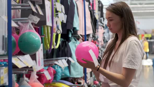 Female Buyer is Choosing Balls in Supermarket