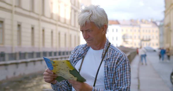 Senior Male Tourist Exploring Town with Map