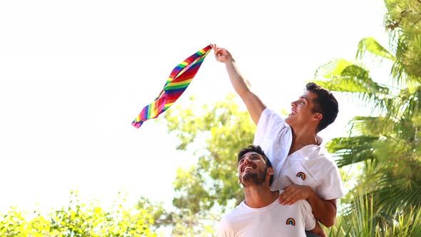 Gay Couple Together Spending Moments of Happiness  Waving Flag in Green Park