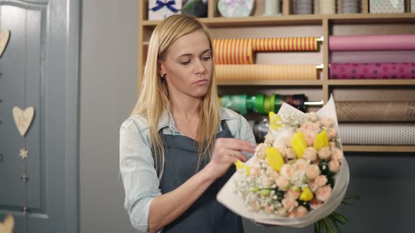 Female Blonde Florist Arranging Modern Bouquet and Choosing the Perfect Riband for It Combining