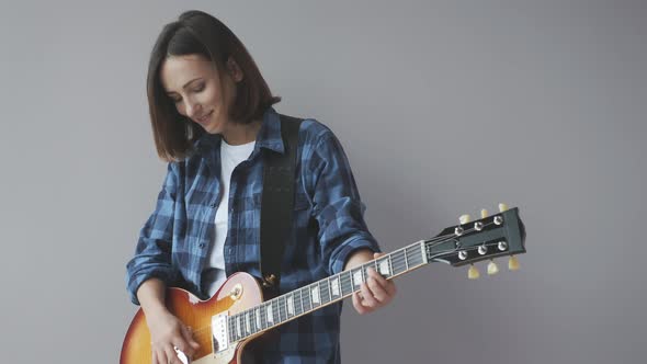 Woman playing electric guitar. Attractive girl with electric guitar playing jazz and blues songs.