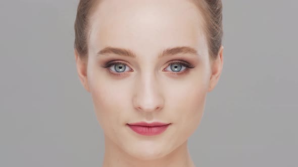 Studio portrait of young, beautiful and natural woman over grey background.