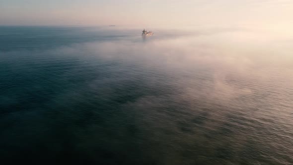 Aerial shot of  sea in foggy day with cargo ships