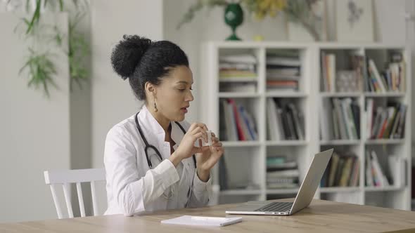 A Young Female Doctor Conducts an Online Video Consultation with a Patient Using a Laptop