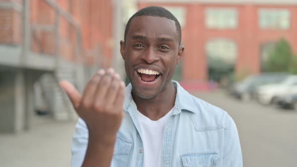 Outdoor Portrait of African Man Pointing at the Camera and Inviting