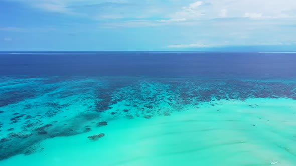 Aerial drone shot landscape of marine seashore beach adventure by turquoise sea with white sandy bac