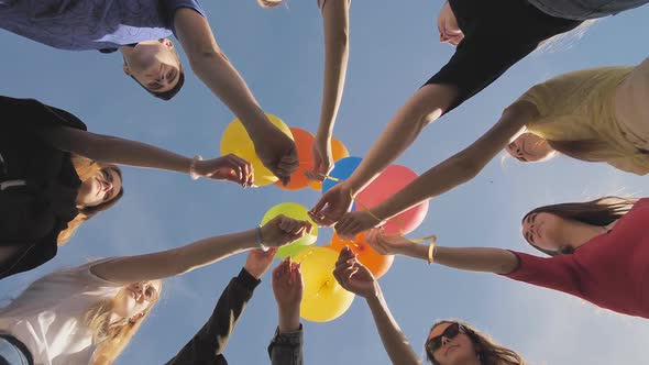 A Group of Friends Release Colorful Balloons Into the Sky