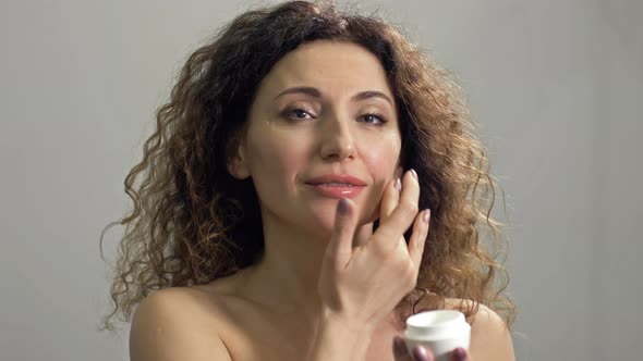 Beautiful Mature Woman Holding Jar of Skin Cream for Face