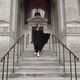 Girl in a long black dress runs down the stairs at entrance to New York library. - VideoHive Item for Sale