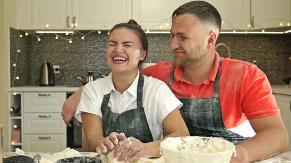 Nice Married Couple Is Preparing Something in the Kitchen. Both Are Having a Lot of Fun