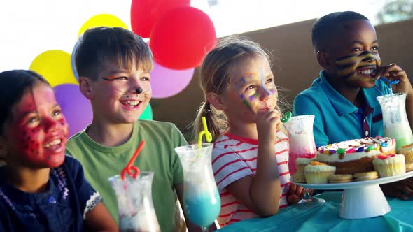 Kids having sweet food and drinks in the playground