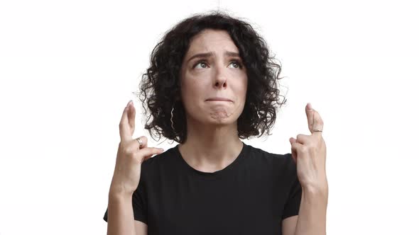 Closeup of Worried Pretty Girl with Short Curly Hairstyle Wearing Black Tshirt Looking Up Hopeful