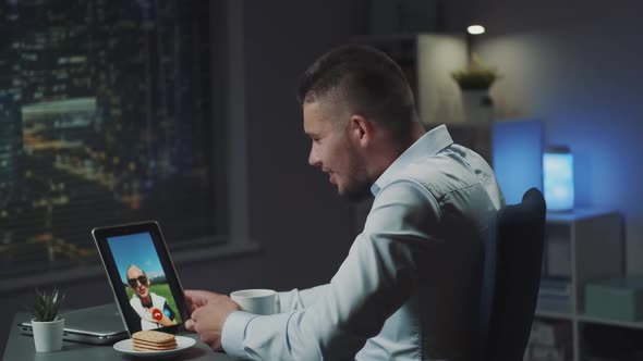 Young Man Using Tablet for Making Video Call with His Girlfriend