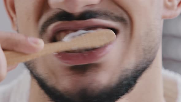 Extreme Closeup Unrecognizable Bearded Man Brushing Teeth with White Paste Whitening Agent with