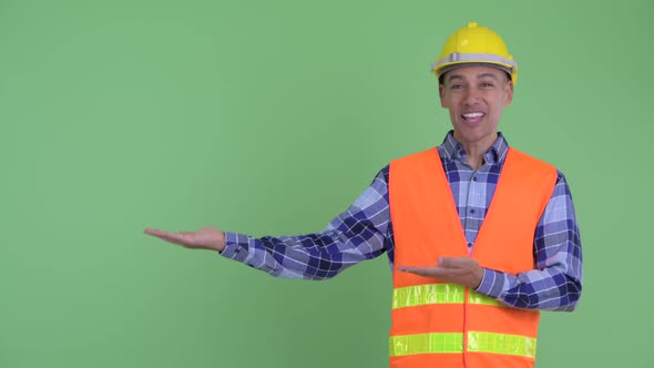 Happy Multi Ethnic Man Construction Worker Talking While Showing Something