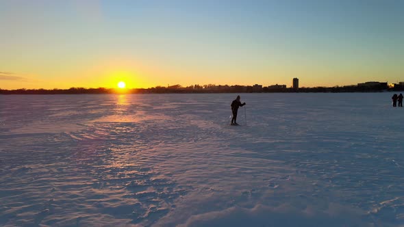 skiing over a frozen lake during sunset, minneapolis minnesota winter sports, enjoying out doors, tr