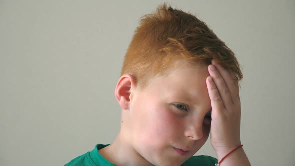 Portrait of Serious Red Hair Boy with Freckles. Desperate Kid Thinks About His Problems Indoor