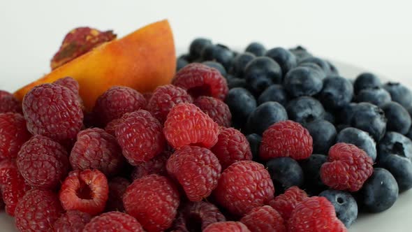 Assorted fruits and berries on a white background rotation 360. Summer fruit raspberry peach,