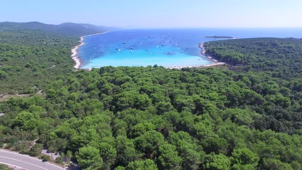 Aerial view of boats in a beautiful azure lagoon with highway in the foreground