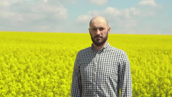 Portrait of a Young Bearded Farmer on Rapeseed Blooming Plants