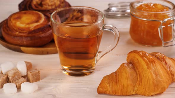 Unrecognizable Person Taking Tea From Table with Desserts