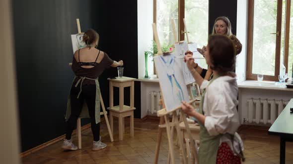 Beautiful Female Students Painting at Art Lesson in Studio