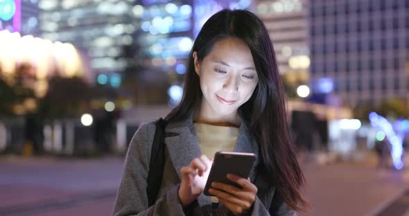 Woman use of mobile phone in Hong Kong at night