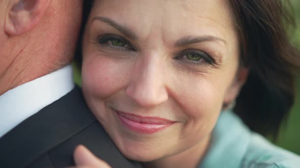 Closeup Face of Smiling Happy Woman with Green Eyes Looking at Camera Hugging Man