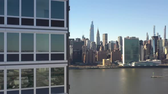 An aerial view from over Queens, NY on a sunny day with blue skies. The camera, close up to a new lu