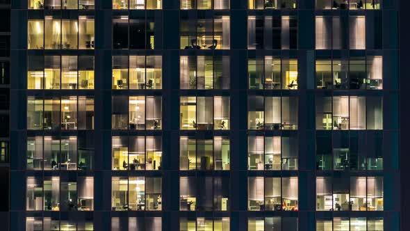 Window of the Multistorey Building of Glass and Steel Lighting and People Within Timelapse