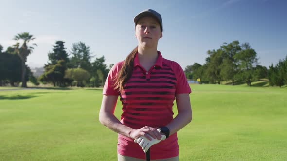 Portrait of female caucasian golf player smiling while standing at golf course