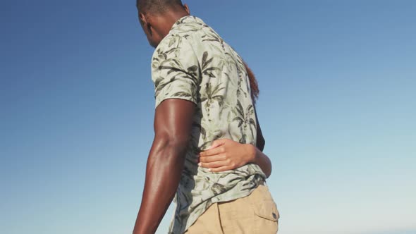 African American couple walking seaside