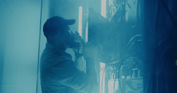 Bearded Man Repairing LED Monitor in Smoke