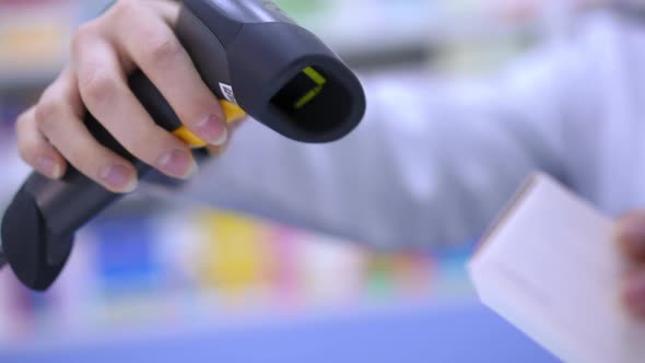 Closeup Scanning Bar Code of Pills with Scanner in Pharmacy Indoors in Slow Motion