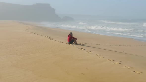 Handsome Young Man Enjoying Beautiful Sunrise on a Sandy Beach