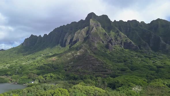 Aerial view of Kualoa mountains in Oahu with blue sky and clouds