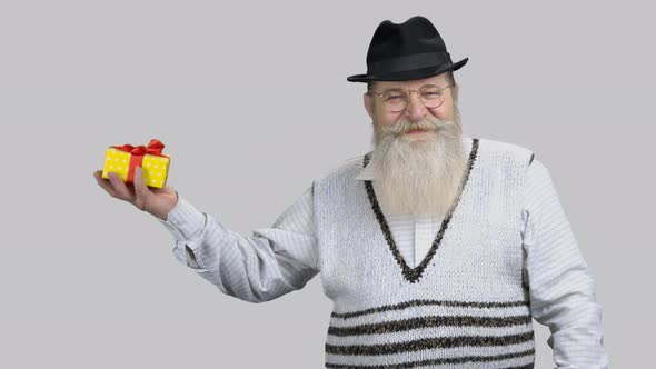 Old Retired Grandpa Adjusting Point Finger at Gift Box