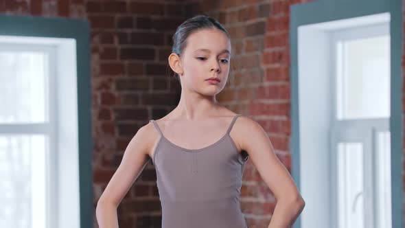 A Little Ballerina Girl Training Movements in the Studio
