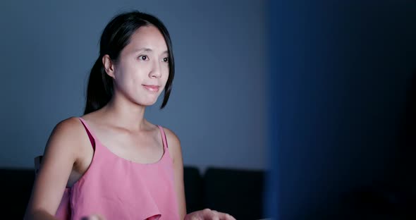 Woman using desktop computer at night