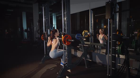 Woman Bodybuilder Doing Workout Lunge Exercise With Barbell Machine Training Hands and Legs in Gym