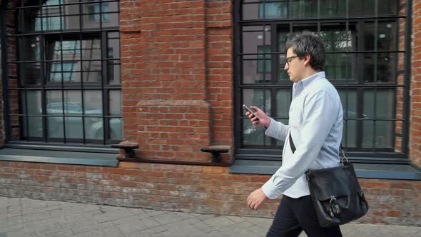 Portrait Profile Shot of Man in Eyeglasses and Blue Shirt Walking Along the Street