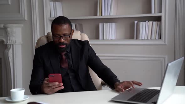 Serious African-American Bearded Man in a Black Suit, Shirt, Stylish Glasses. A Businessman Is
