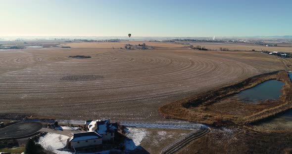 Early morning drone flight with hot air balloon, geese, clear skies, and light snow.