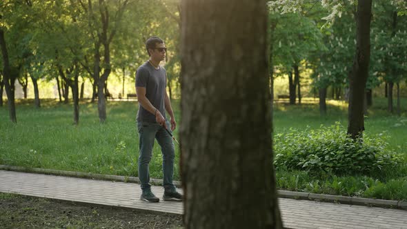 Blind Man Walks with a Cane at the Park