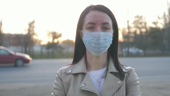 Young Woman in a Medical Mask for Protection From the Epidemic on the Street in the City