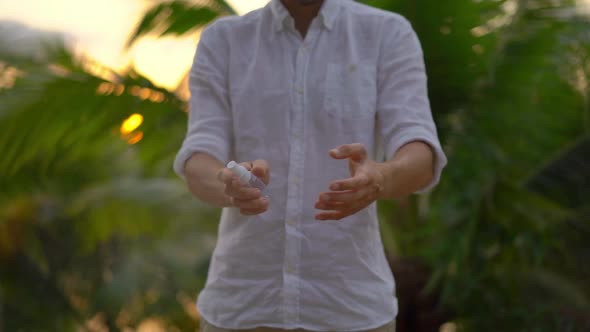 Shot of a Young Man Applying an Antimosquito Repellent Spray on His Skin