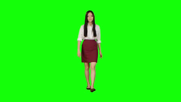 Girl of Asian Appearance Goes To Work and Waves Her Hand. Green Screen